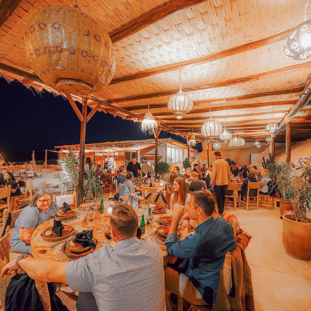 ضيوف يستمتعون بوجبة غداء بجانب المسبح في أكفاي - Invités profitant d’un déjeuner dans le restaurant marocain